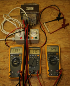 A transformer (without load) being measured with the three voltmeters method. The three multimeters show, from left to right, U1, U2 and U3. The resistor (top right) is 165Ohm 17W. (click to enlarge)