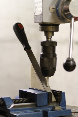 Chamfering the rod on the drill-press by drilling against a flat file tilted at 45 degrees.